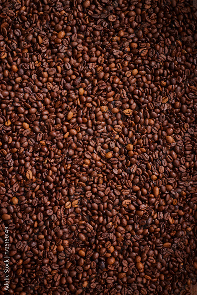 A high angle view of a pile of coffee beans spread out. A high angle view of a pile of coffee beans spread out.