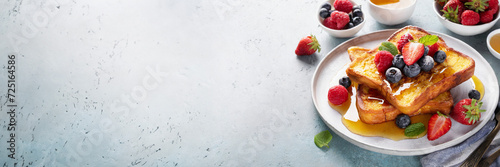 French toast with fresh berries and syrup on white background, panoramic shot with copy space