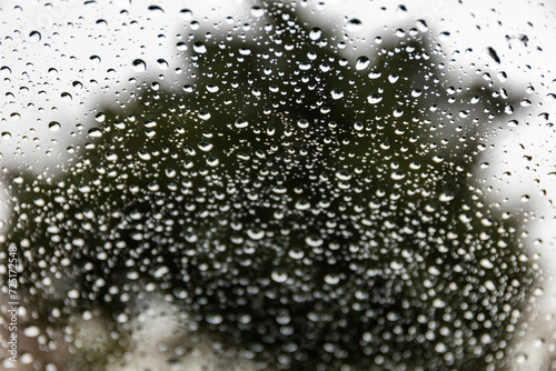 Rain drops through a cars windshield with focus on the top part and unfocused on the bottom with room for text
