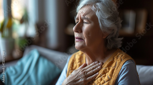 Old woman senior holding his chest with a sad and pained expression photo