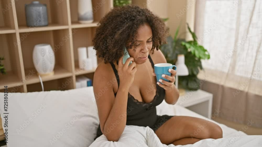 African american woman with braids using phone and holding mug in bedroom African american woman with braids using phone and holding mug in bedroom