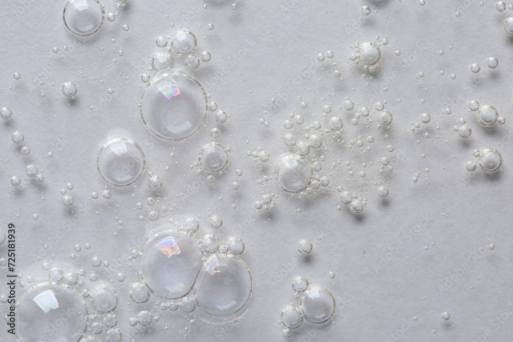 Clear cosmetic serum on white background, macro view