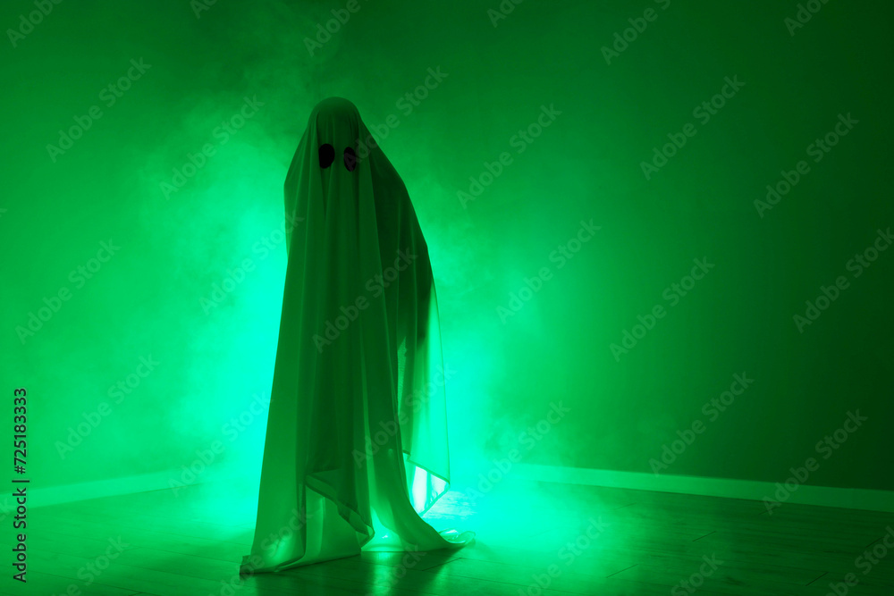 Creepy ghost. Woman covered with sheet in green light, space for text Creepy ghost. Woman covered with sheet in green light, space for text