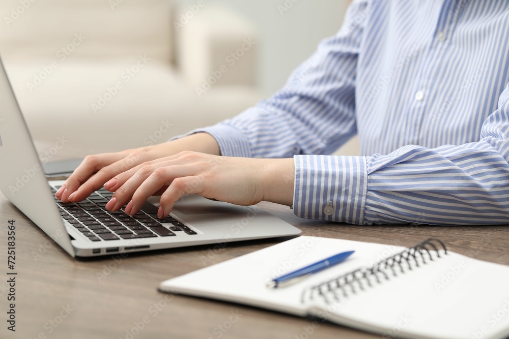 Fototapeta premium E-learning. Woman using laptop during online lesson at table indoors, closeup