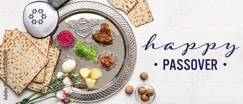 Passover Seder plate with traditional food and Jewish cap on table photo