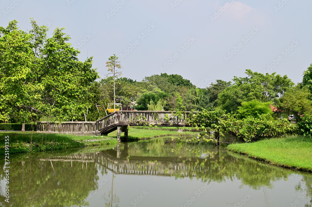 Closeup of Beautiful old cement bridge Covered with trees for crossing the canal inside the park with natural background at Thailand.