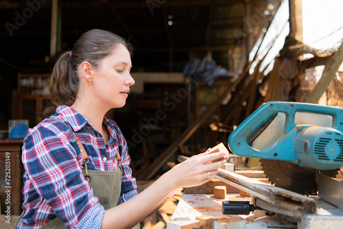 Portrait of female carpenter working in her workshop at countertop