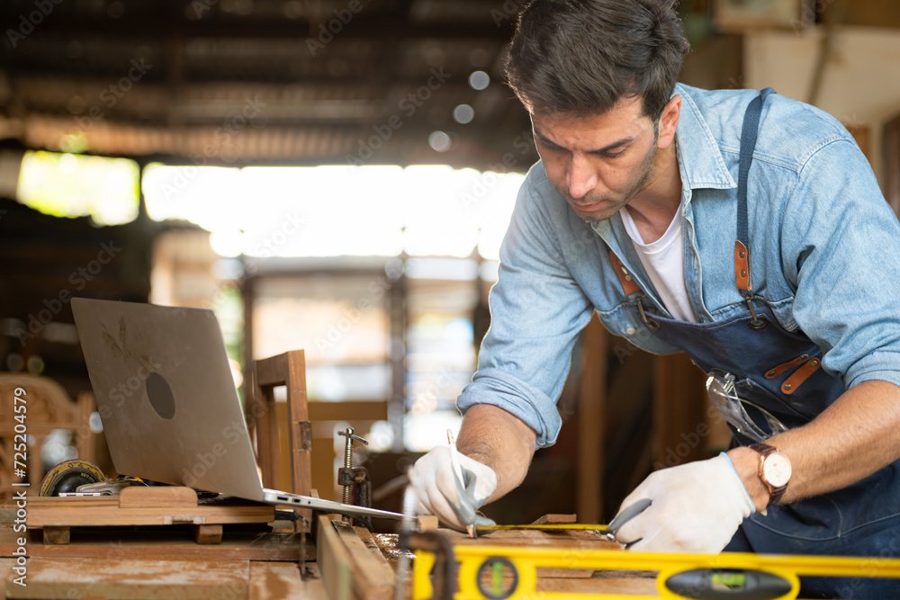 Carpenter working at his carpentry shop. Eyesight is utilized to ensure accuracy. Carpenter working at his carpentry shop. Eyesight is utilized to ensure accuracy.