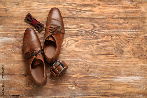 Male shoes with bow tie and belt on wooden background. Father's Day celebration