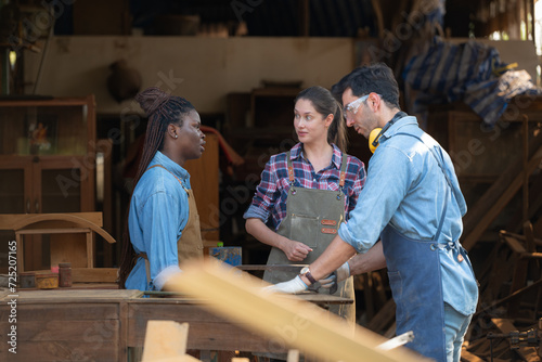 Carpenter and his assistant working together in a carpentry workshop