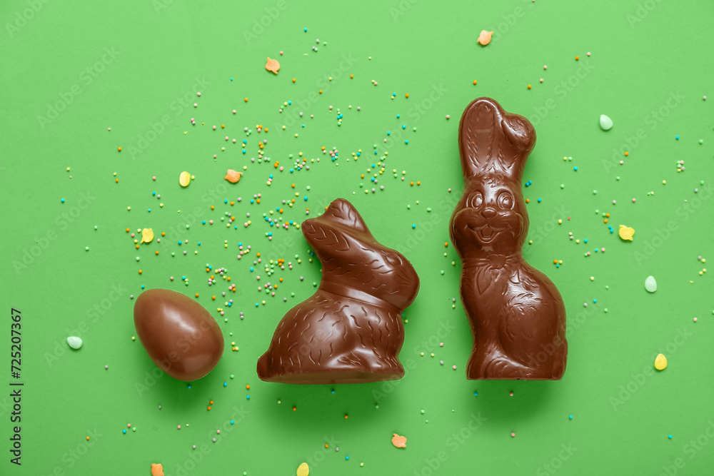 Chocolate Easter egg with sprinkles and bunnies on green background Chocolate Easter egg with sprinkles and bunnies on green background