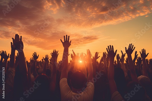 Group of people raising their hands during sunset
