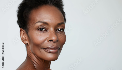 Radiant Middle-Aged Woman with Natural Black Hair on Neutral Background with Copy Space