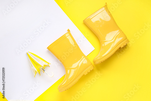 Foto Mini stylish umbrella and gumboots on colorful background