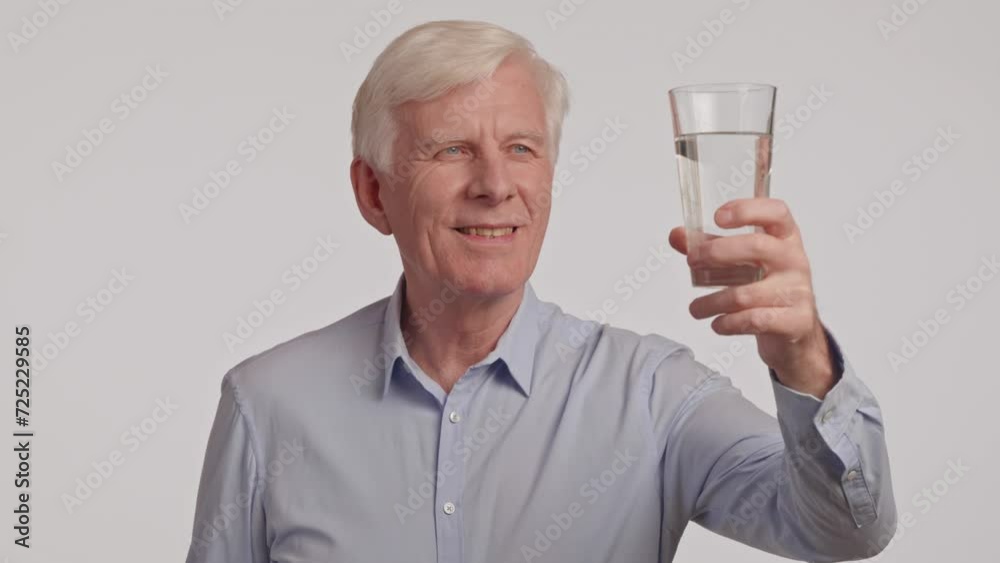 Portrait of thirsty gray haired senior man drinking clear water from glass. Portrait of thirsty gray haired senior man drinking clear water from glass.