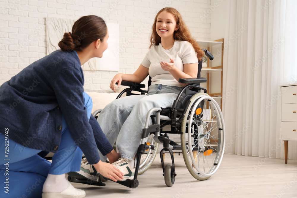 Young redhead woman in wheelchair with nurse at home Young redhead woman in wheelchair with nurse at home