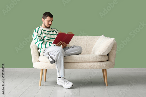 Handsome young man reading ...