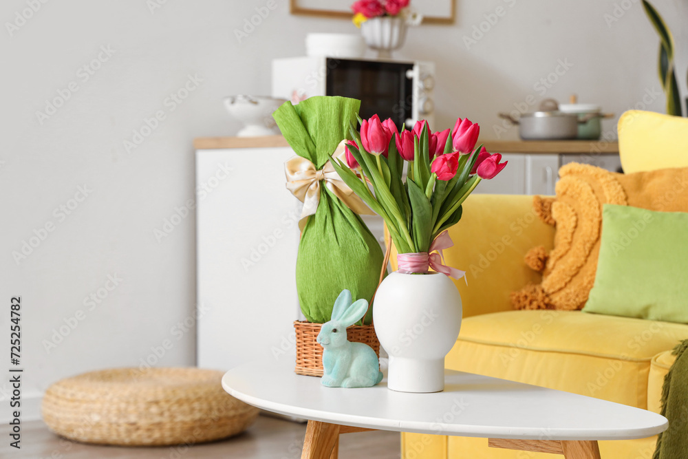 Vase with tulips, Easter rabbit and gift egg on table in kitchen Vase with tulips, Easter rabbit and gift egg on table in kitchen