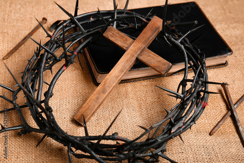 Crown of thorns with wooden cross  Bible and nails on fabric background