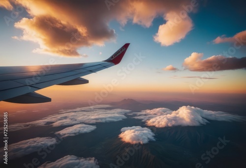 The view from the airplane window to the clouds and sunset. Airplane wing above thick pink and orange clouds. Wonderful breathtaking view. © Алексей Ковалев