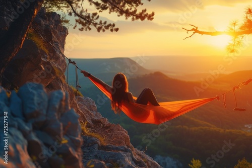Woman hiker resting after climbing in a hammock at sunset photo