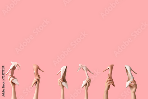 Women with stylish heels on pink background