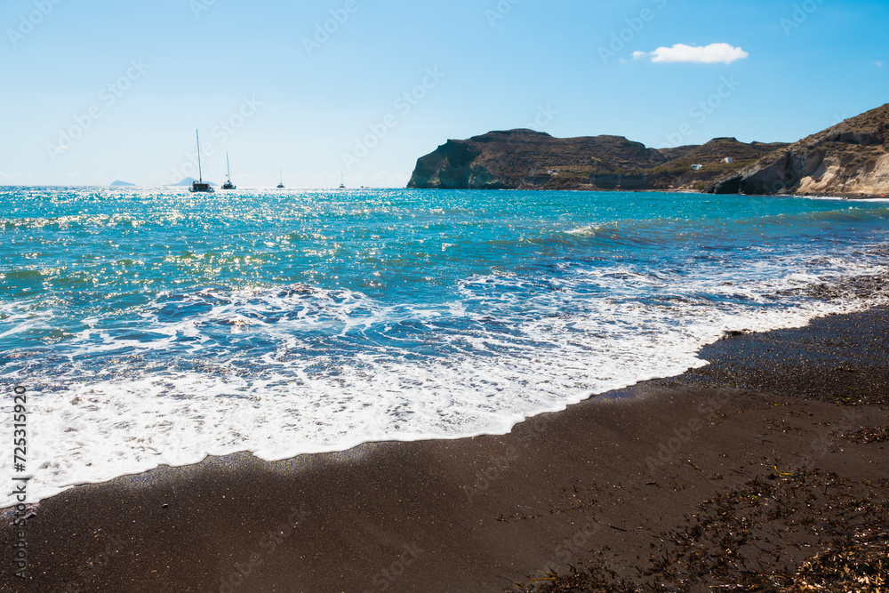 Red beach in Santorini island, Greece. Black volcanic sand and the blue sea.