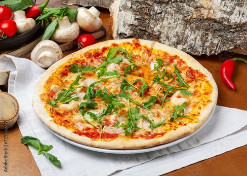 Italian pizza with seafood and arugula on wooden background