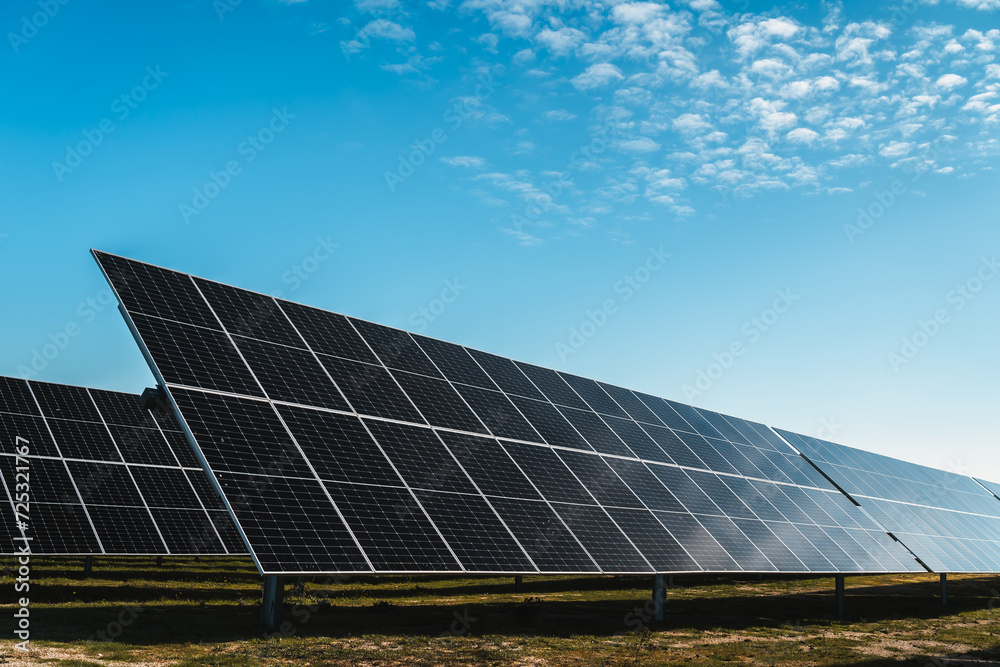 row of solar panels under blue sky, in new solar photovoltaic plant, bright sunny day row of solar panels under blue sky, in new solar photovoltaic plant, bright sunny day