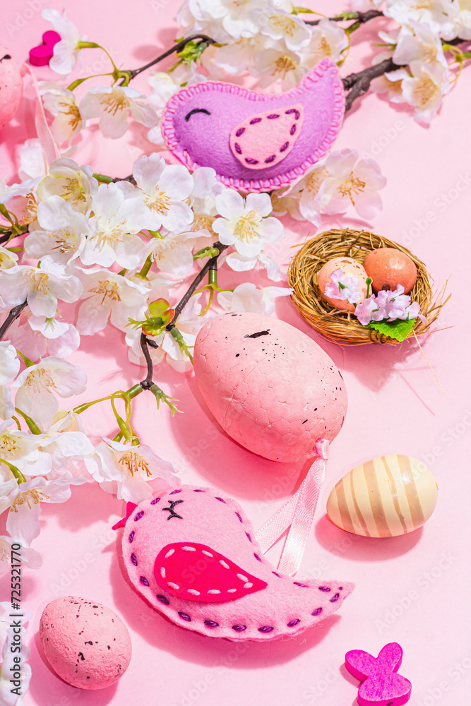 Gentle Easter composition with cherry flowers and handmade felt birds. Decorative eggs and nest