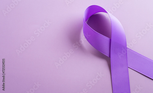 Purple ribbon on pastel paper background for supporting World Cancer Day campaign on February 4.