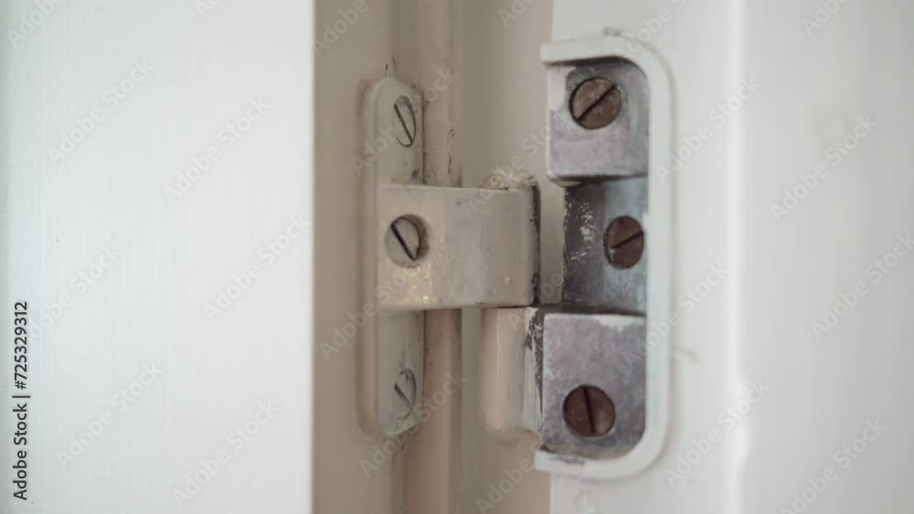 Squeaky door hinge lubrication with spray lubricant. Close up Squeaky door hinge lubrication with spray lubricant. Close up