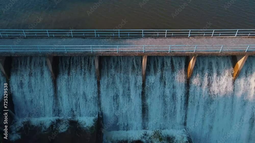 Aerial shot of water flowing through the floodgate of a dam of a lake made for irrigation. Aerial shot of water flowing through the floodgate of a dam of a lake made for irrigation.