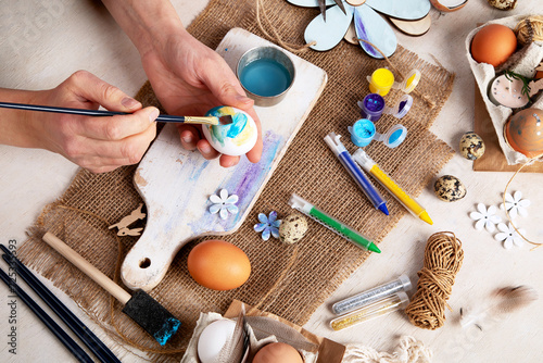 Easter DIY. Easter preparation, multi-colored paints and a brush for decorating eggs. Creativity with children.