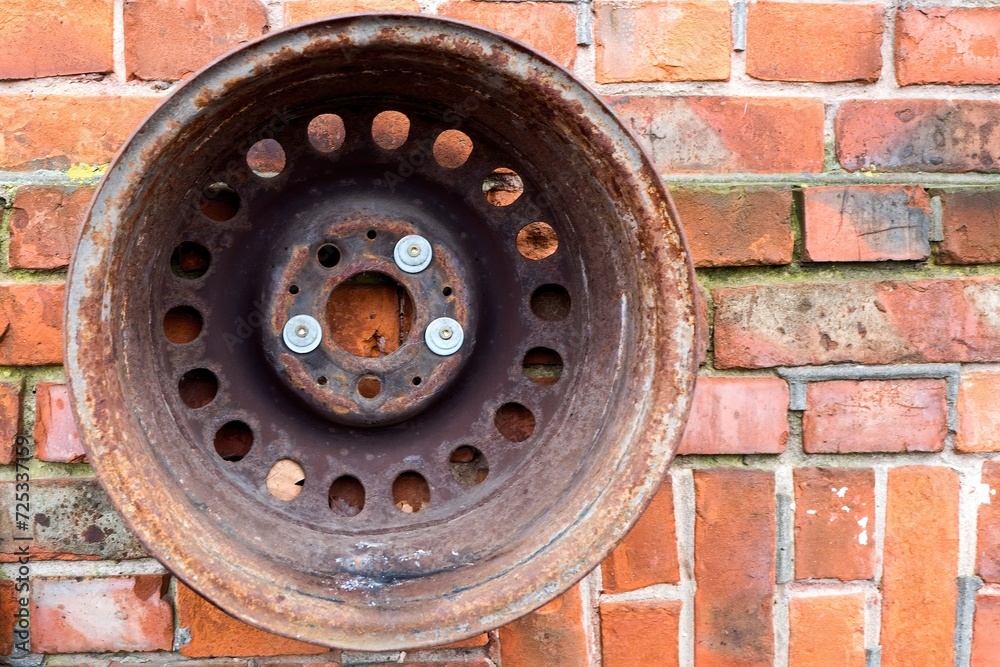 Car disk on a brick wall.