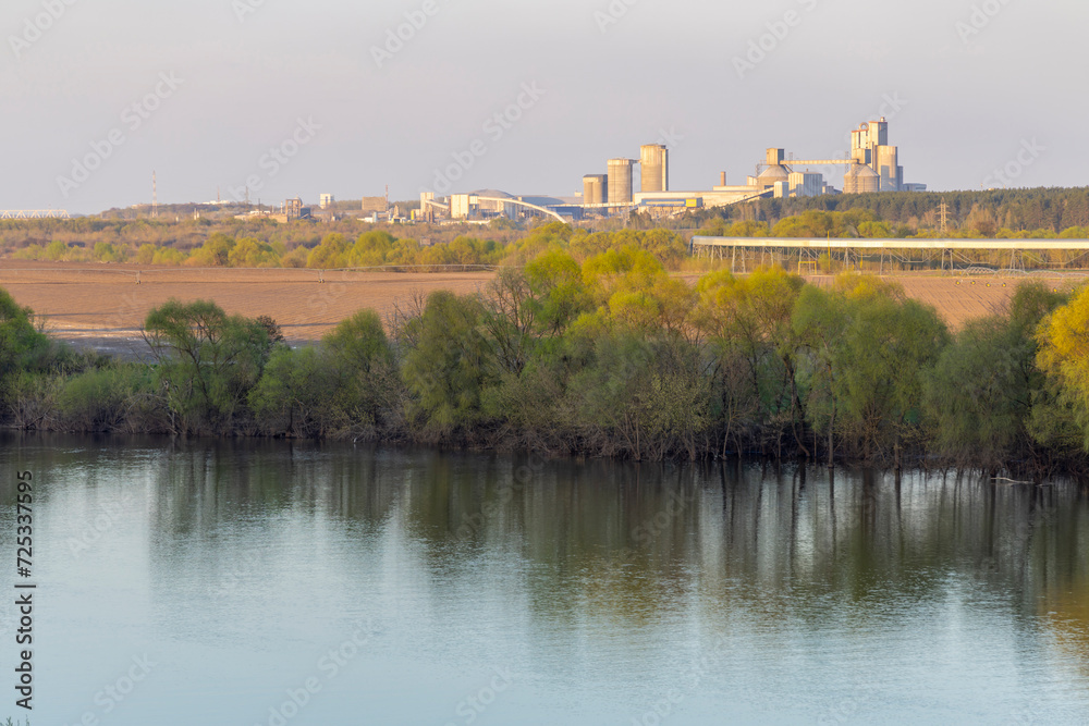 Industrial landscape near the river, large factory next to the river