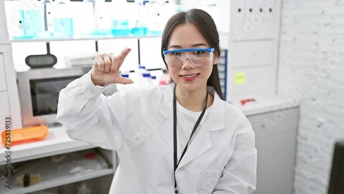 Wallpaper Mural Little-big discovery! young chinese scientist, beautiful and confident, show-measure concept. gesturing small size sign with fingers in her lab. Torontodigital.ca