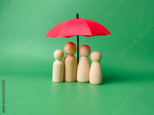 A wooden peg doll family cover by red umbrella