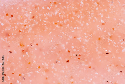 Cosmetics scrub texture swatch, body peeling in peach fuzz color. Top view.