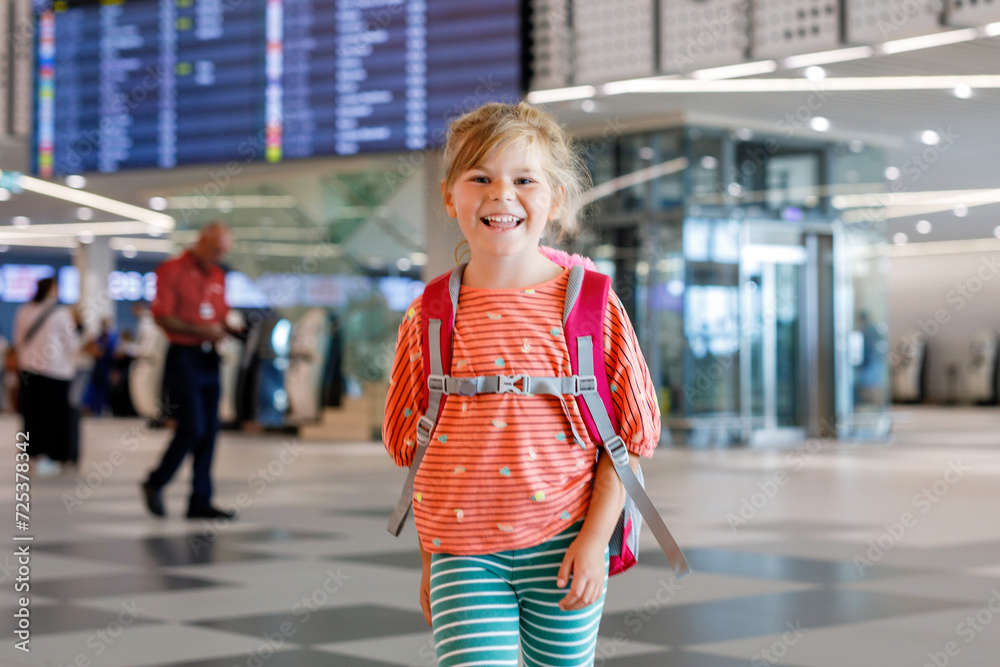 Little preschool girl at airport terminal. Happy child going on