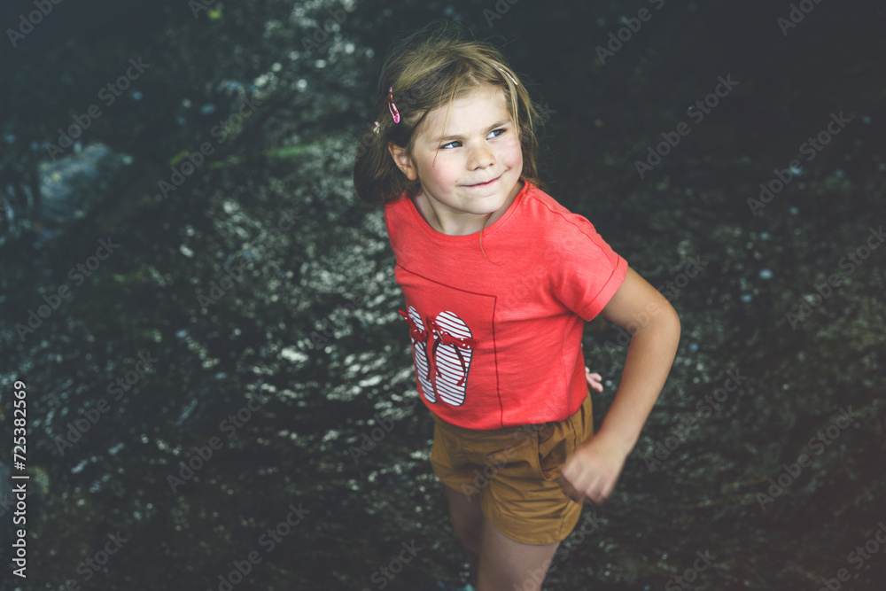 A Happy Girl Embraces the Joys of Childhood as She Explores a Summer Creek, Immersing Herself in Nature's Wonders and Playful Discoveries. Preschool Child and Summertime. A Happy Girl Embraces the Joys of Childhood as She Explores a Summer Creek, Immersing Herself in Nature's Wonders and Playful Discoveries. Preschool Child and Summertime.