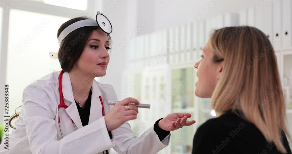 ENT doctor examines patient throat and shines flashlight ENT doctor examines patient throat and shines flashlight