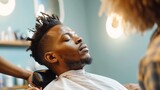 African American man sitting in chair and getting haircut in salon