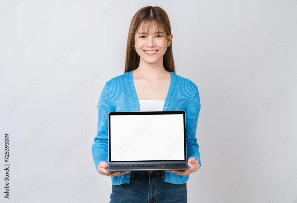 Cheerful beautiful Asian woman holding laptop on grey background. Cheerful beautiful Asian woman holding laptop on grey background.