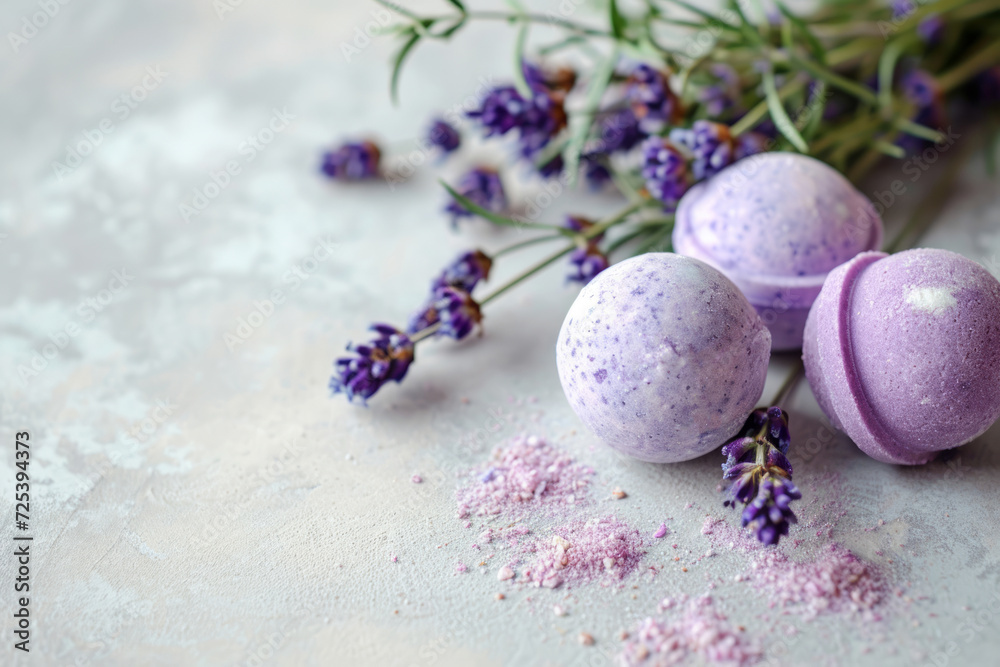 Obraz premium Purple bath bombs with dried lavender buds by fresh sprigs on a light concrete background with copy space, for natural handmade cosmetic stores and wellness concept