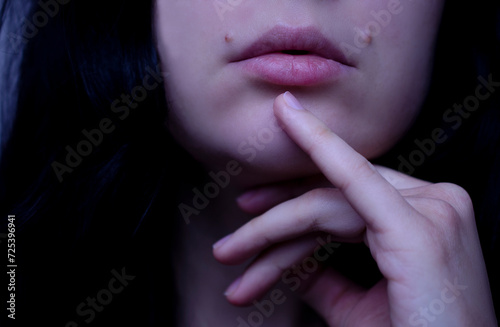 Portrait of a beautiful brunette woman. Natural beauty. Hand and lips close-up.