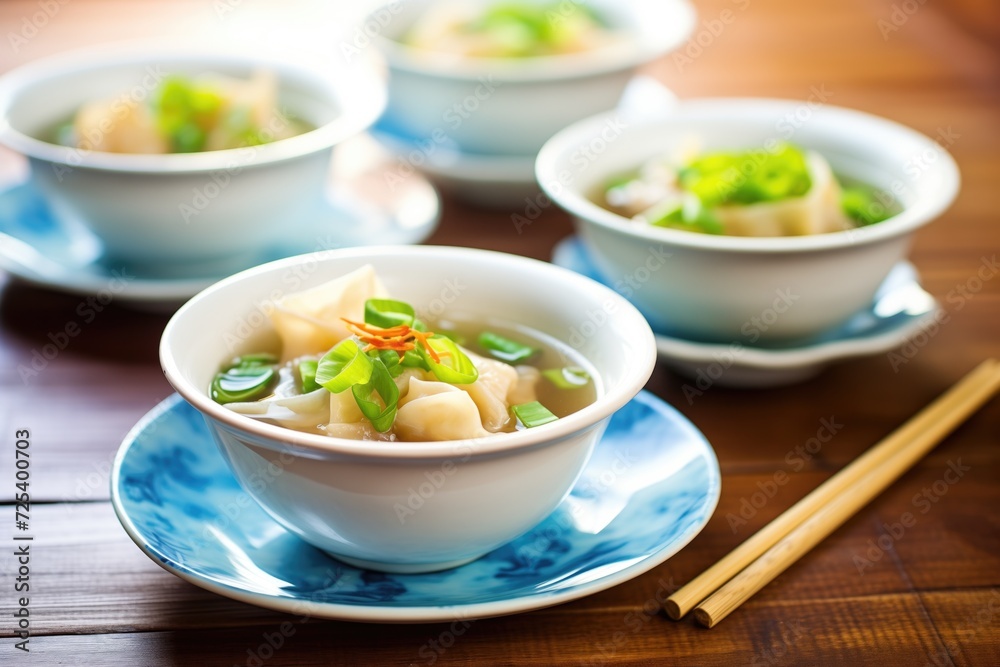 bowls of wonton soup with green onion garnish