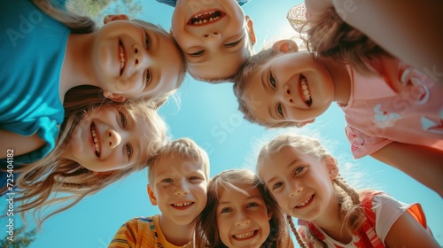 A group of delighted and adorable young children playing together, experiencing joy and fun. A collective portrait captures the happiness of kids huddled together, looking down at the camera