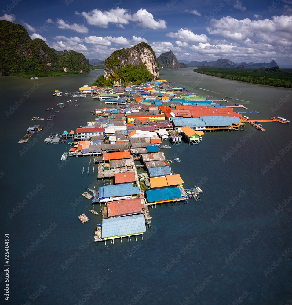 Mesmerizing aerial shot of Koh Panyee, Thailand's floating village. Vibrant stilted structures rise above the turquoise waters, capturing the essence of a unique and captivating way of life