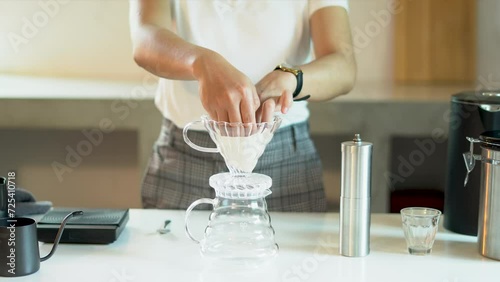 people holding filter paper making coffee for dripping hot coffee into the cup with equipment, tool brewing at kitchen home prepare to make caffeine drinks at home photo